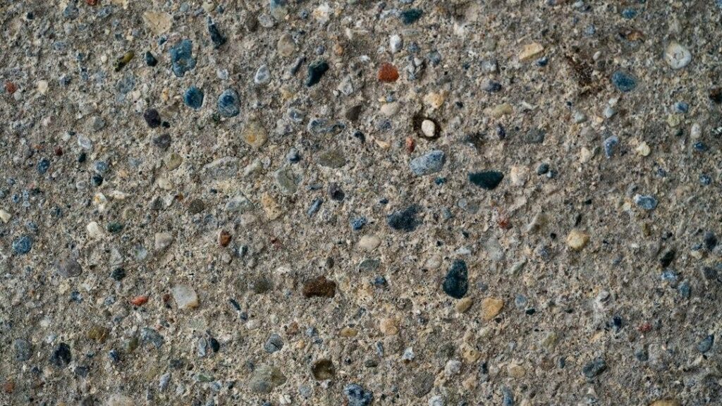 Close view of an exposed aggregate concrete surface with small colored stones